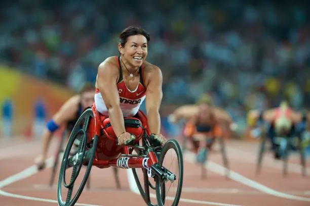 Superación personal y calidad de vida a través del deporte Mujer deportista en silla de ruedas compitiendo con una sonrisa, ejemplo de superación y salud física en el deporte