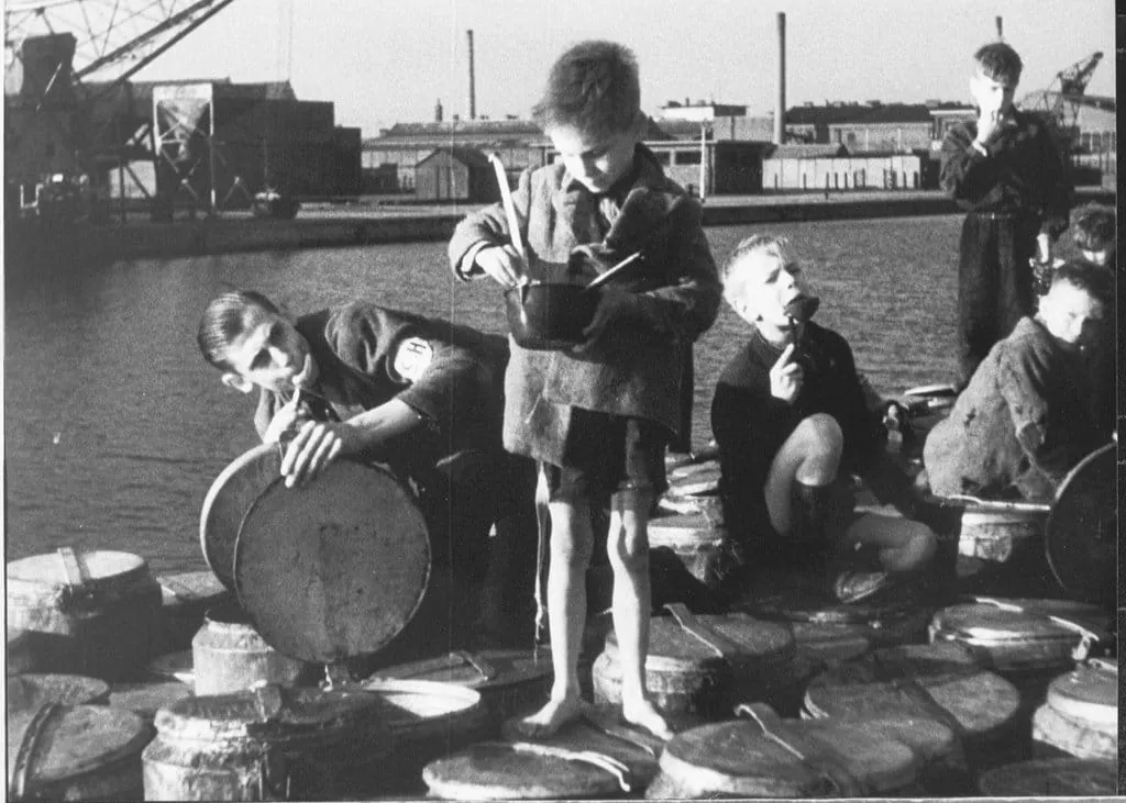 Niños buscando comida durante la hambruna holandesa de 1944, ejemplo histórico de epigenética y salud.