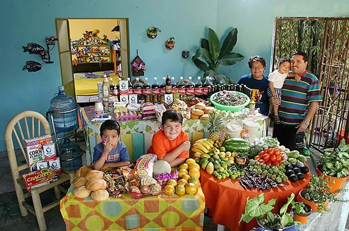 Familia mexicana mostrando su consumo semanal de alimentos, destacando el contraste entre productos frescos y procesados.