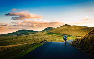 Ciclista recorriendo una carretera de montaña al amanecer, simbolizando el esfuerzo y la constancia para alcanzar metas deportivas.